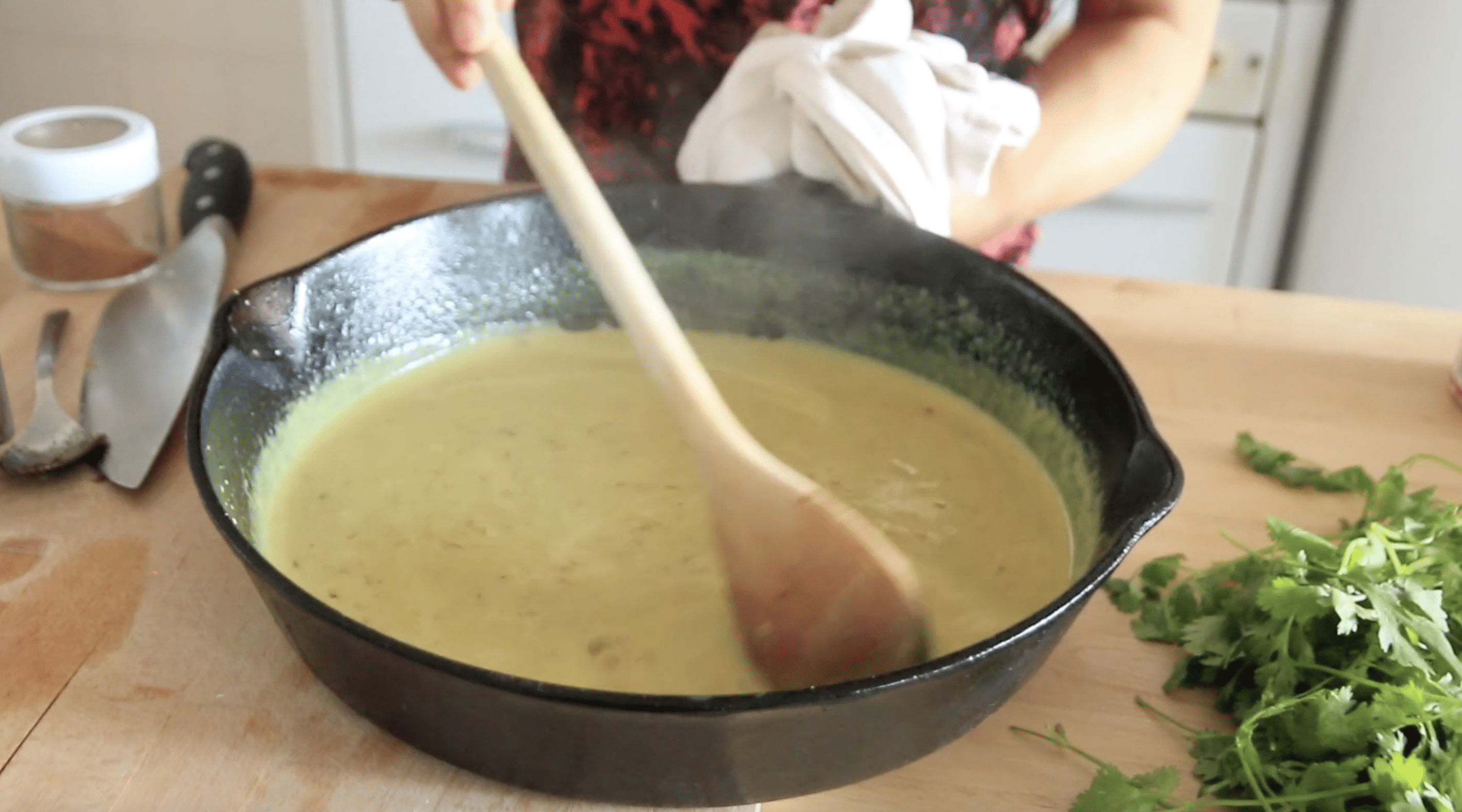 pan with a spoon stirring in coconut milk