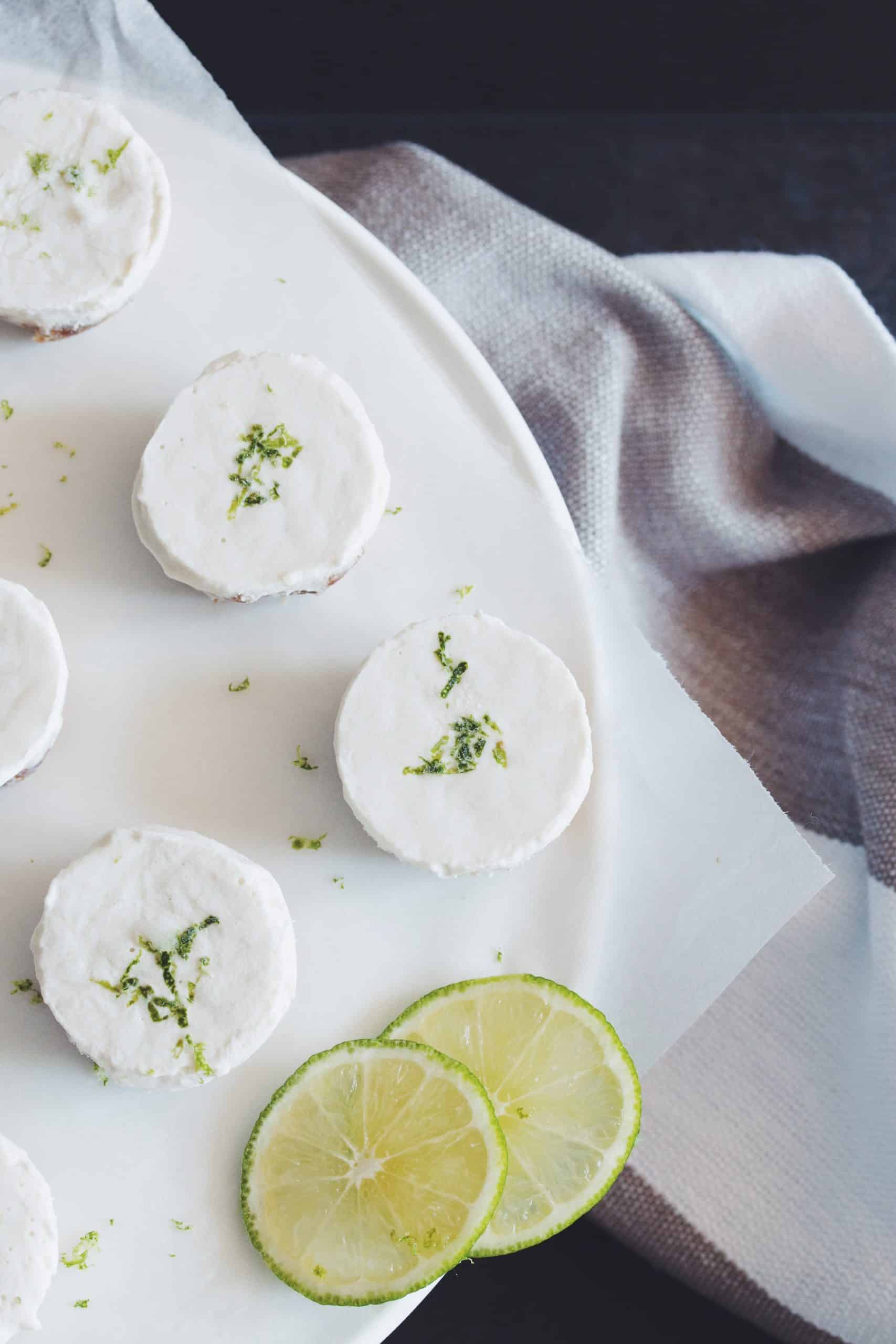 overhead of a plate of mini vegan cheesecake bites garnished with lime slices