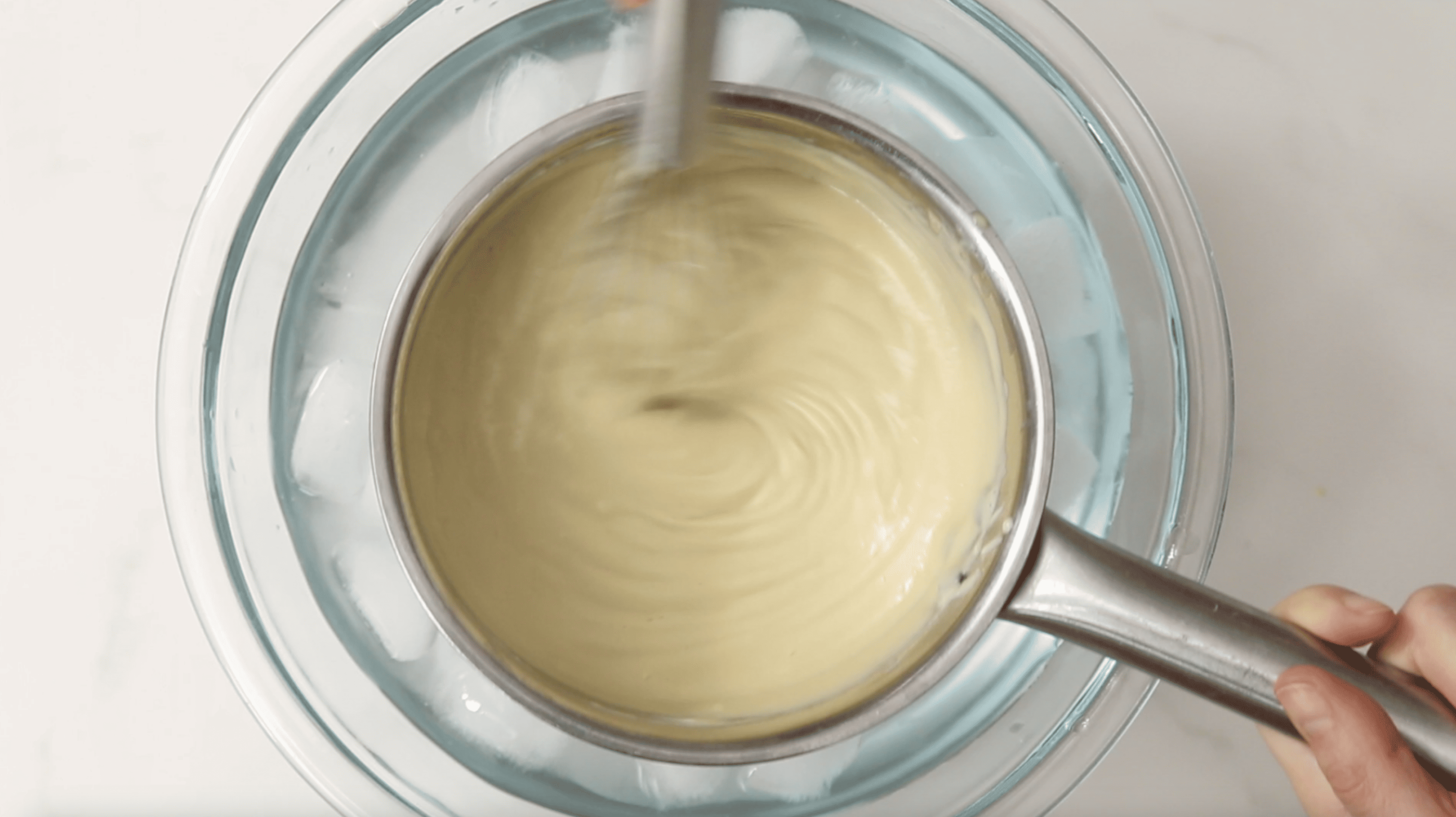 custard in saucepan over an ice bath