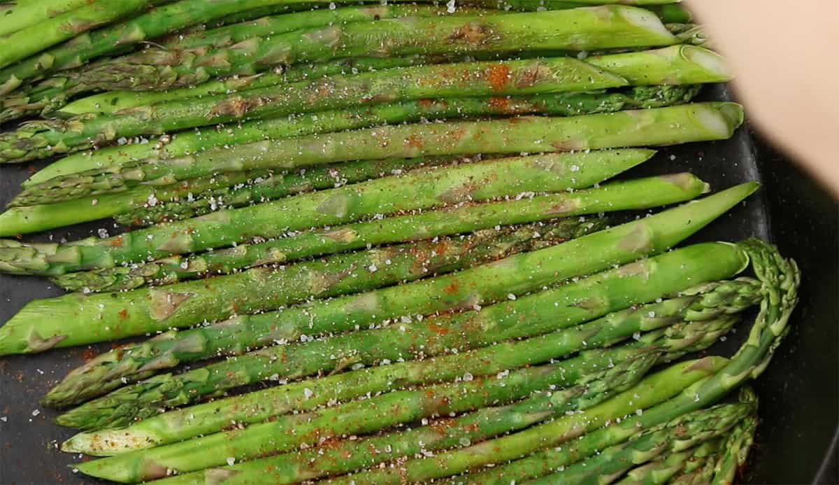 asparagus cooking in a cast iron skillet