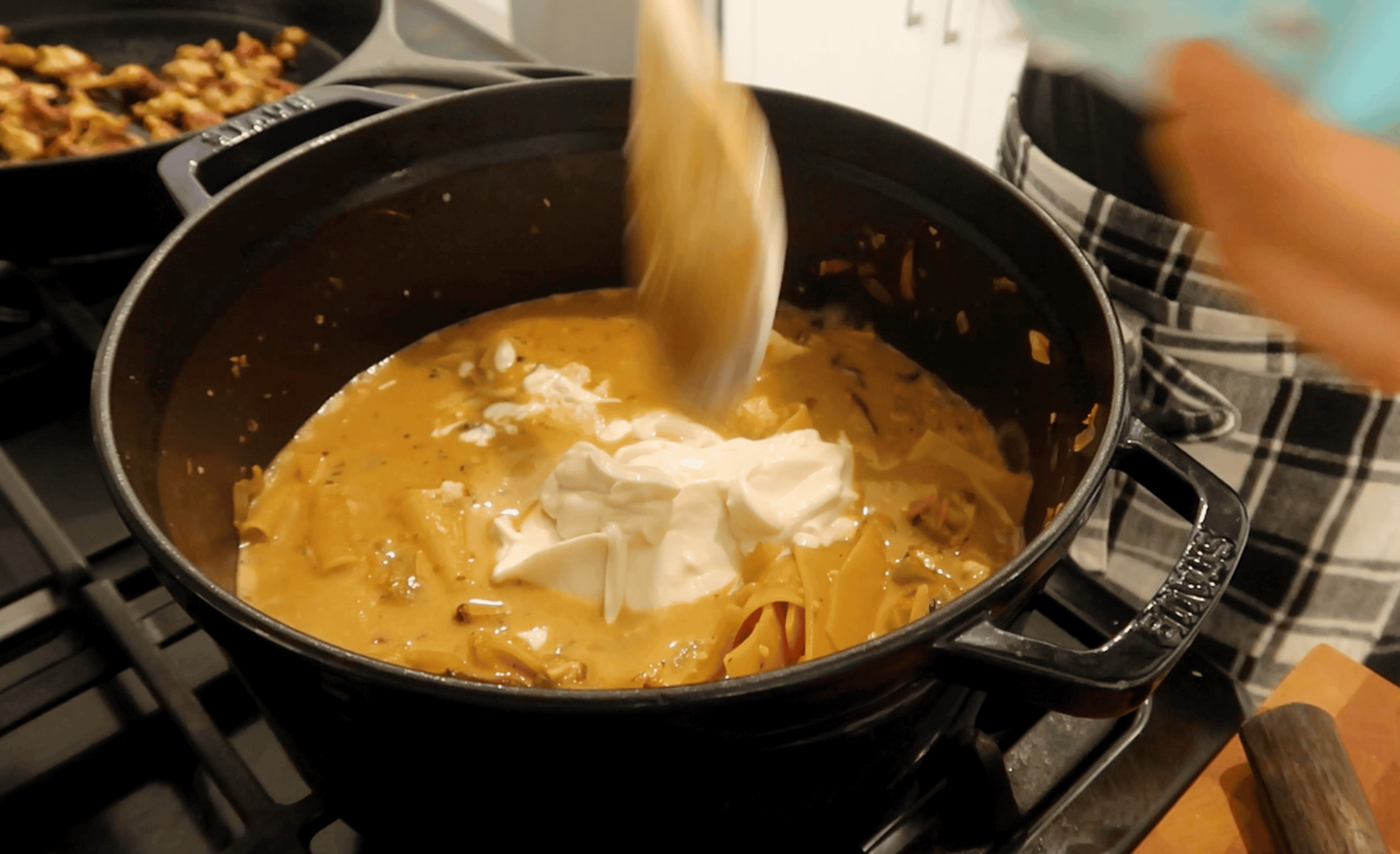 vegan sour cream being adding to a pot of soup