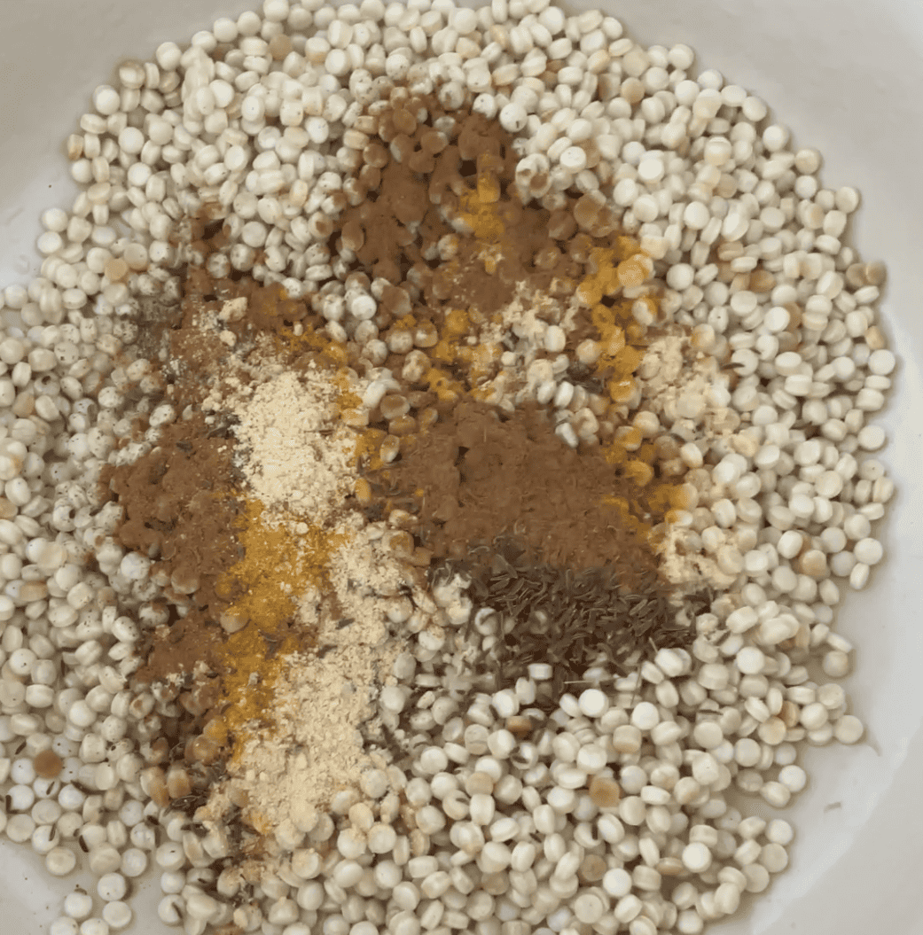 spices added to couscous in a pot