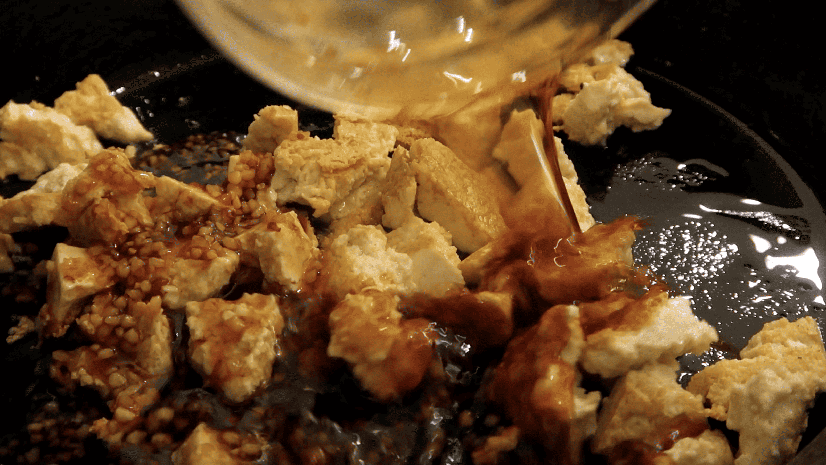 sweet soy sauce being poured onto tofu