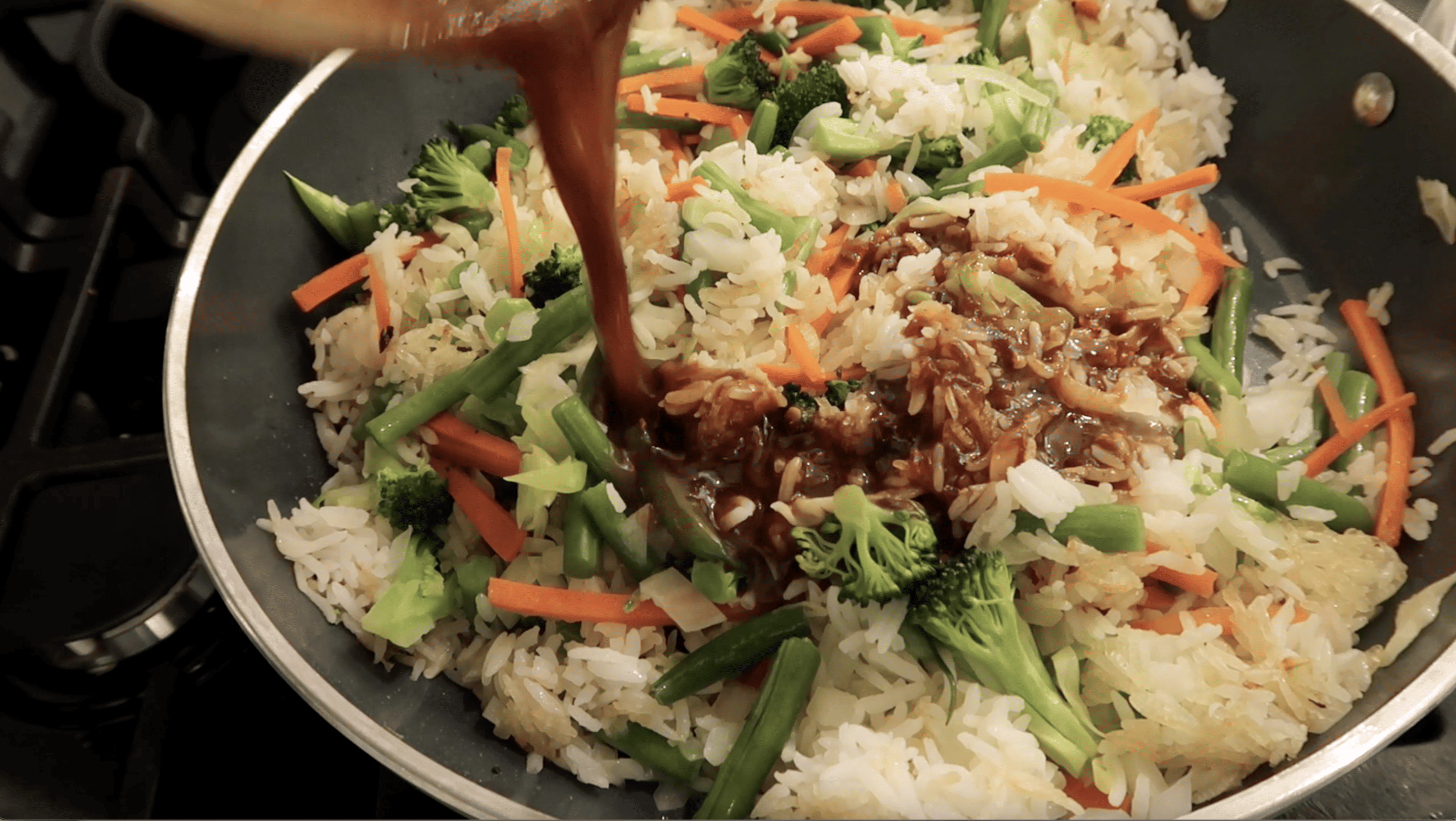 view of a pan with nasi goreng in it and sauce poured into the pan
