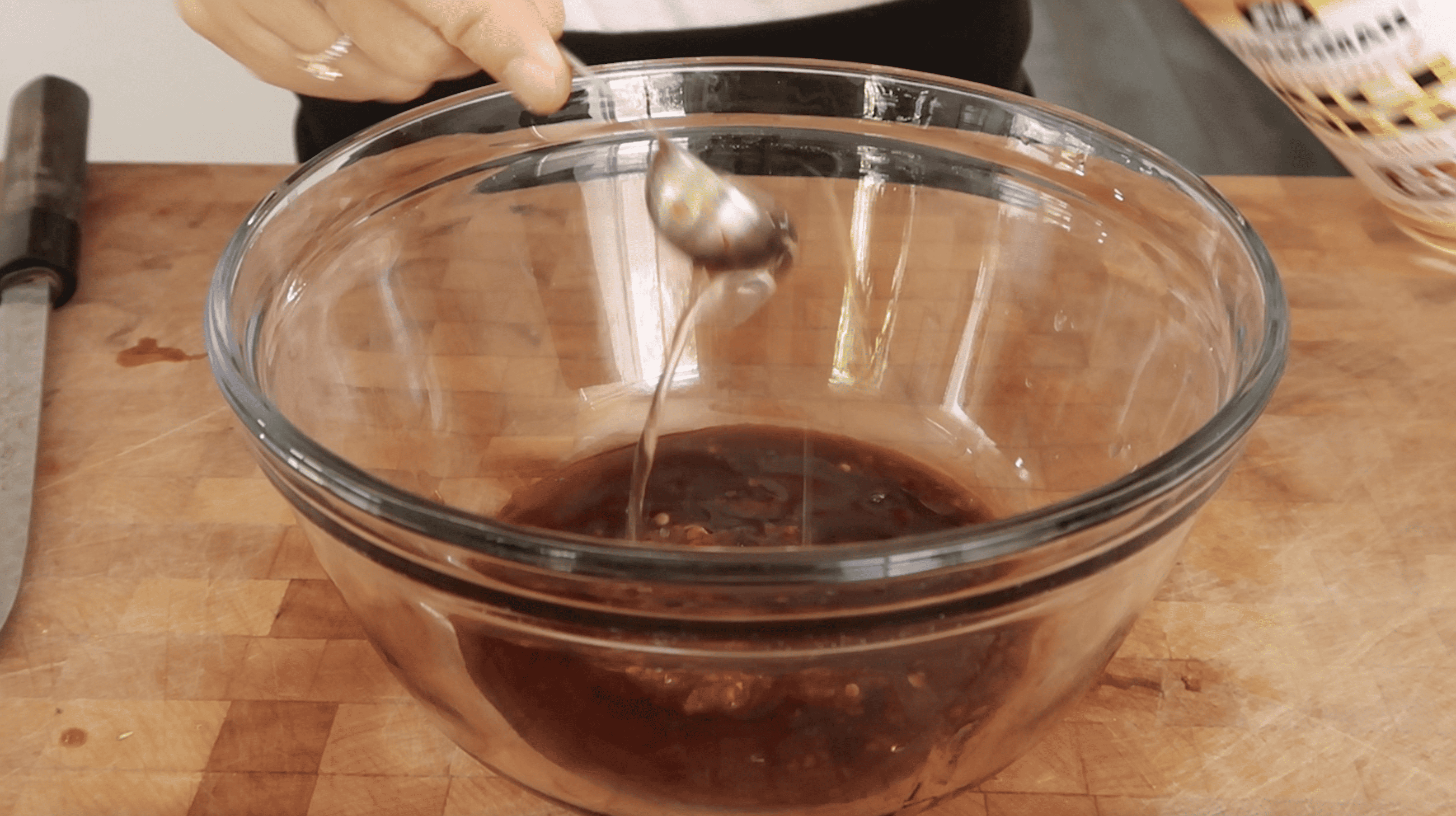 a glass mixing bowl with sauce in it