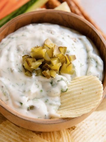 bowl of dill pick dip with a chip sitting in it